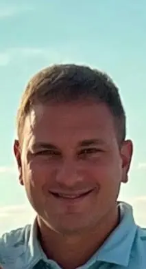A man with short hair is smiling for the camera.